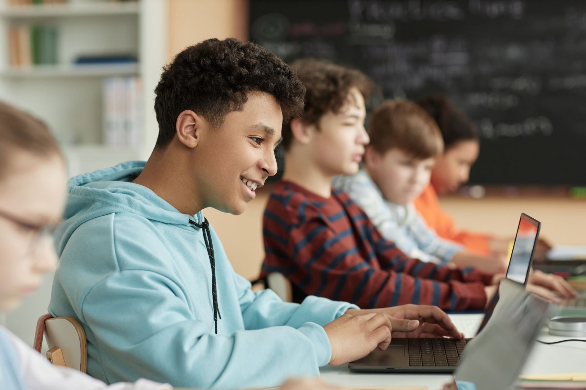 A group of kids in front of their computers learning basic programming concepts with Berlitz Digital School.