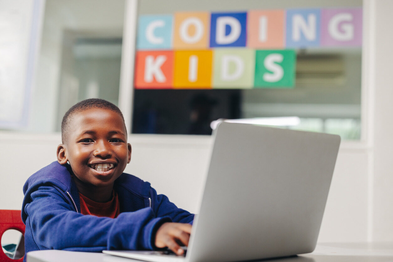 Boy in front of a laptop learning how to develop websites in a programming class for kids with Berlitz Digital School.