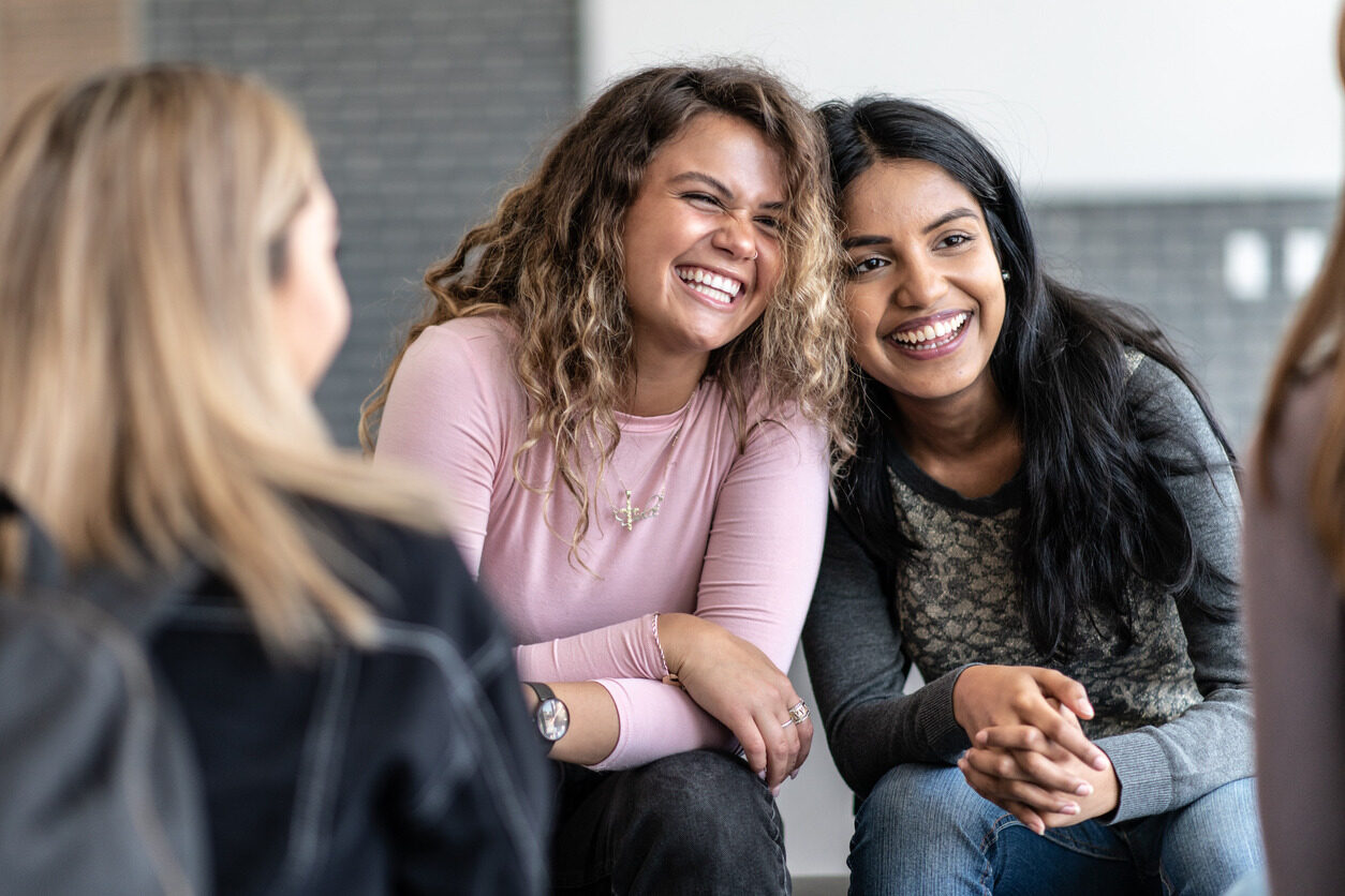 Girls laughing together after their app development class with Berlitz Digital School.