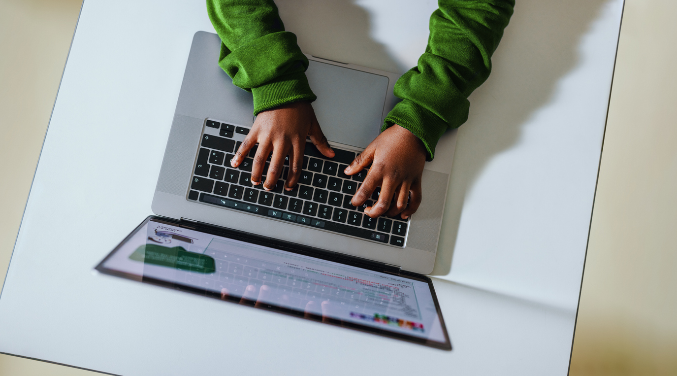 Hands of a students typing on a laptop keyboard.