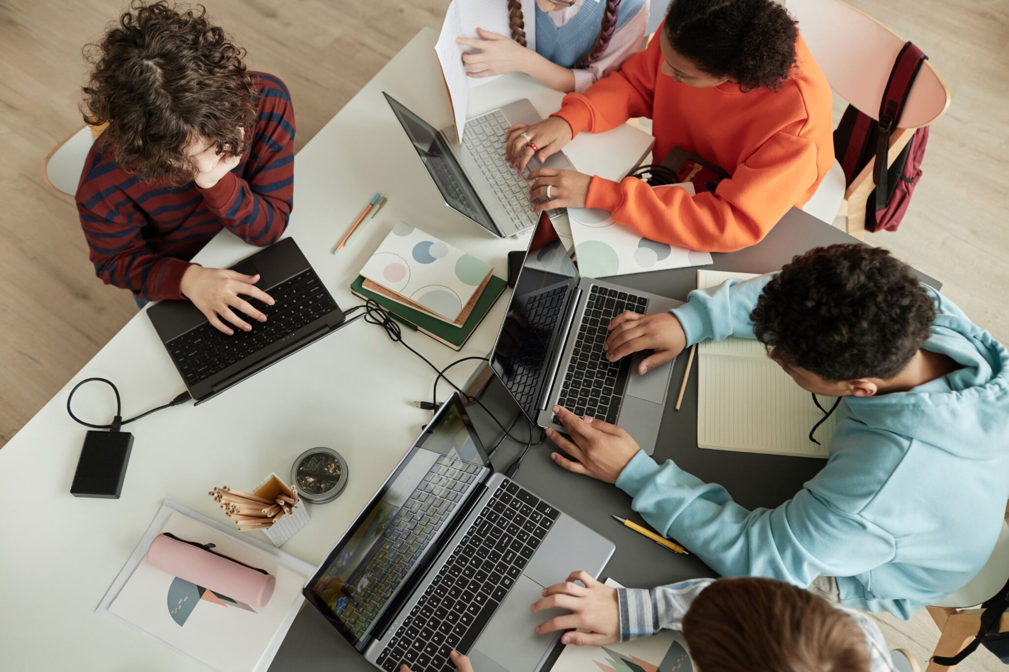 A group of kids attending an Advanced WordPress class for children with Berlitz Digital School and working on their laptops.