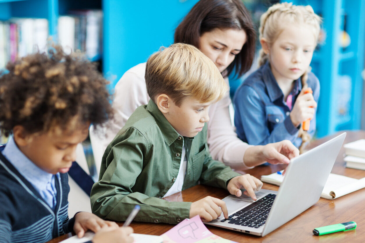 Kids in front of a computer learning how to us Python.