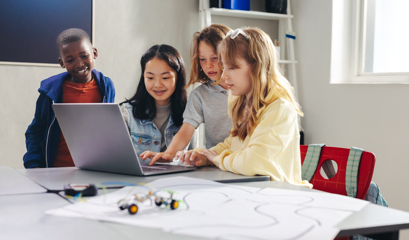 A group of kids in front of a computer learning about Cyber Security in a summer camp with Berlitz Digital School.