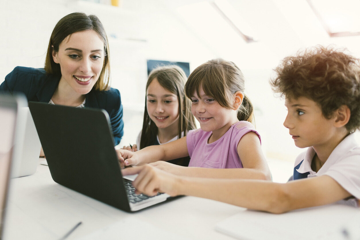 Kids learning to program from their teacher in Berlitz Digital School's Summer School.