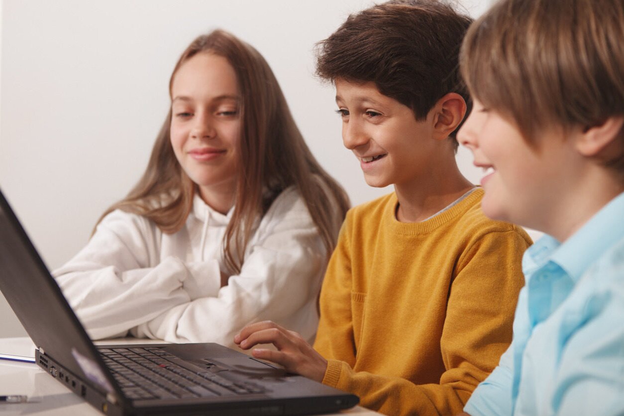 Kids in front of a laptop learning about Python with Berlitz Digital School.