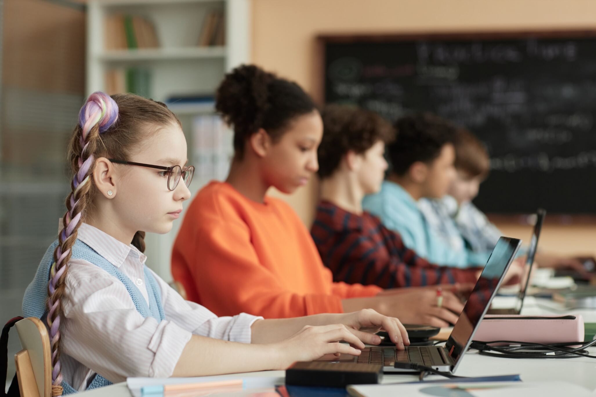 Students sitting in front of their laptops and typing on them during their coding class with Berlitz Digital School.