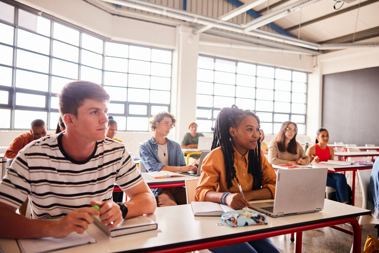 Students sitting in a room in front of their computers and learning about advanced web development for kids and teens with Berlitz Digital School.