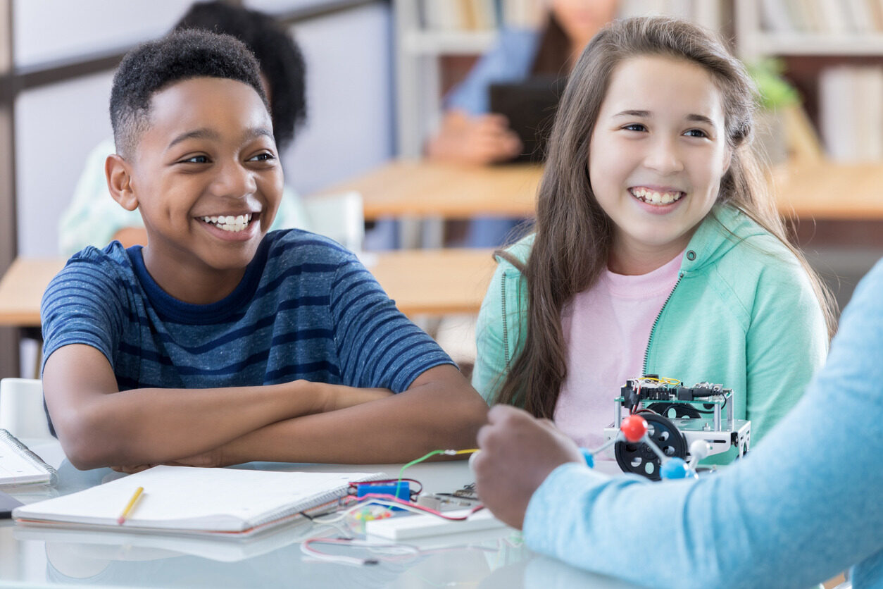 Students smiling and learning about artificial intelligence in short courses.