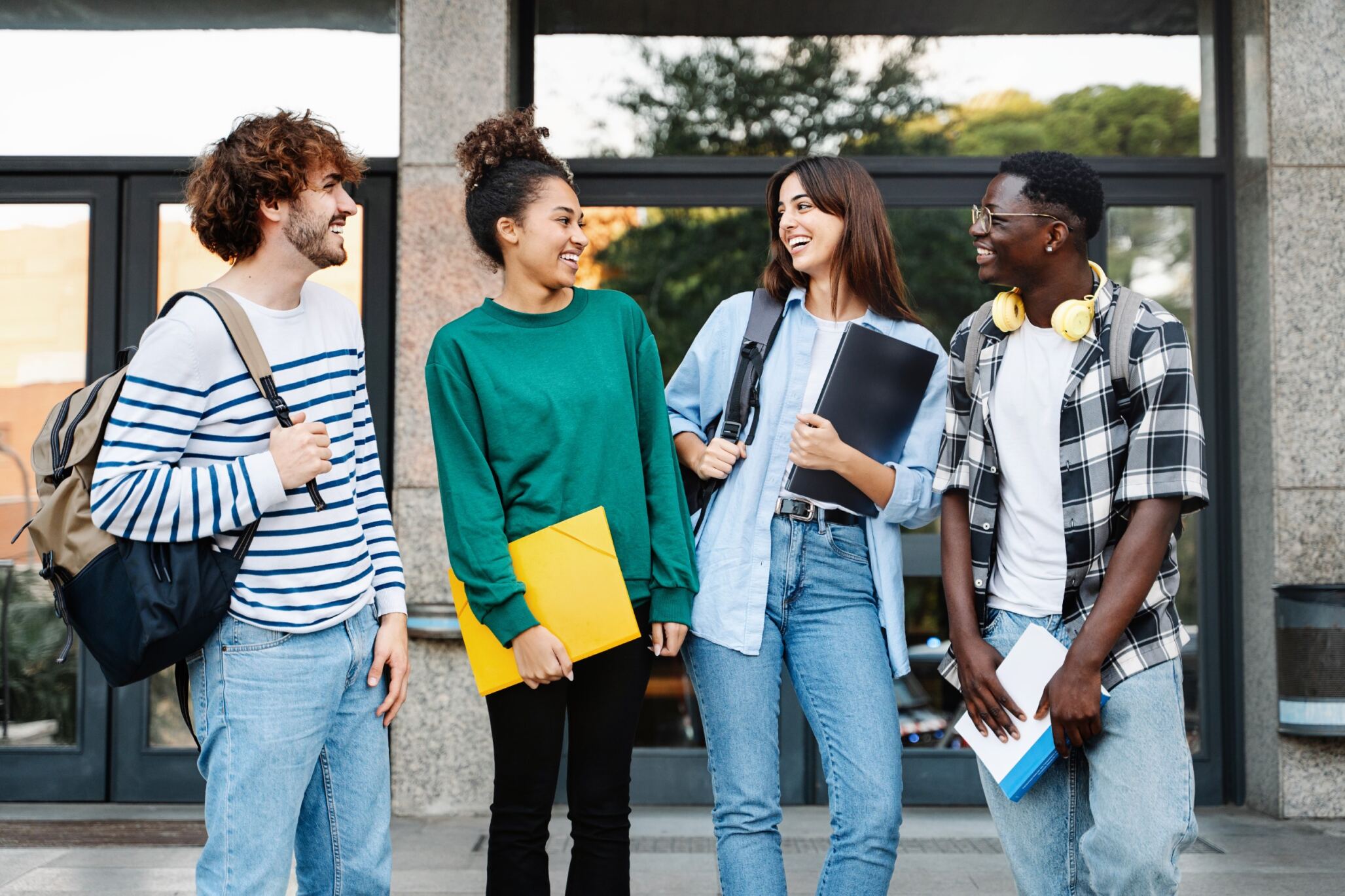 Students in front on a building chatting about their summer camp with Berlitz Digital School..