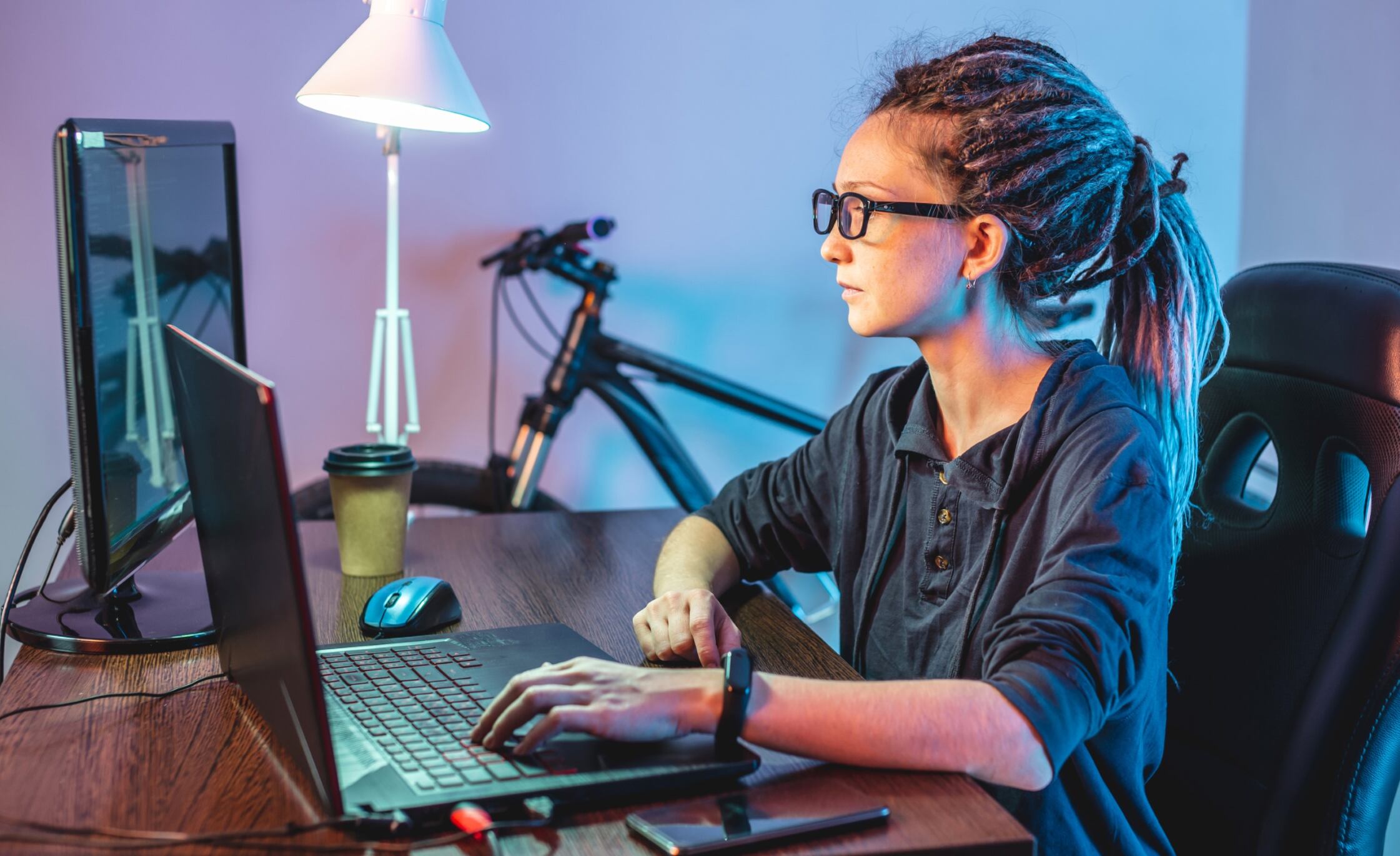 Child in glasses sitting in front of a computer and learning to code with Berlitz Digital School's classes for kids.